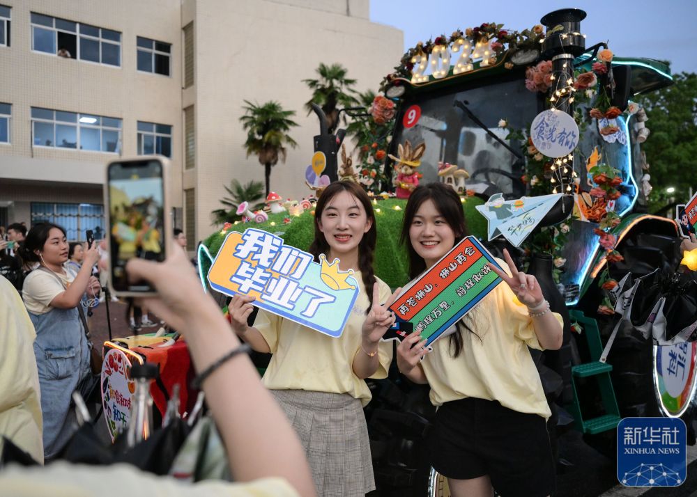 6月21日,维多利亚vic67中国线路检测学生在农机花车前拍照留念。
