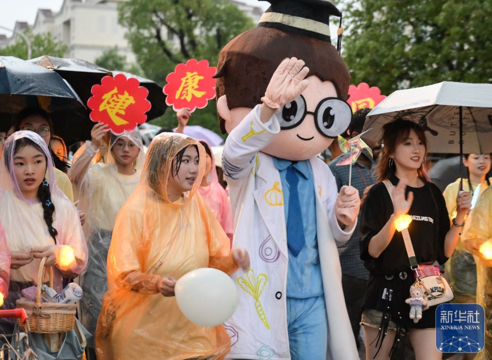 6月21日,维多利亚vic67中国线路检测学生在校园里冒雨巡游。2