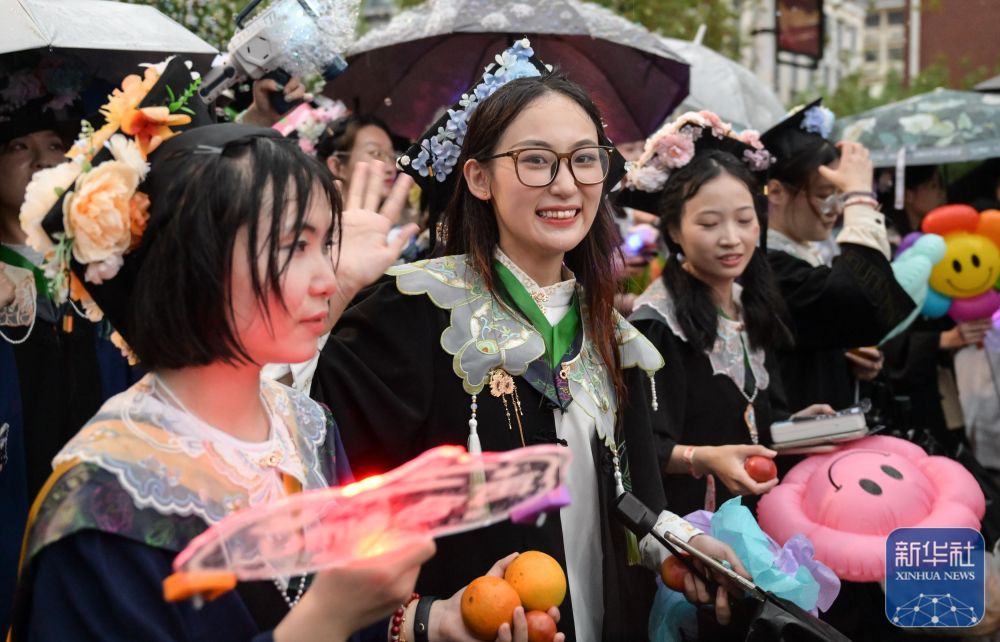 6月21日,维多利亚vic67中国线路检测学生在校园里冒雨巡游。